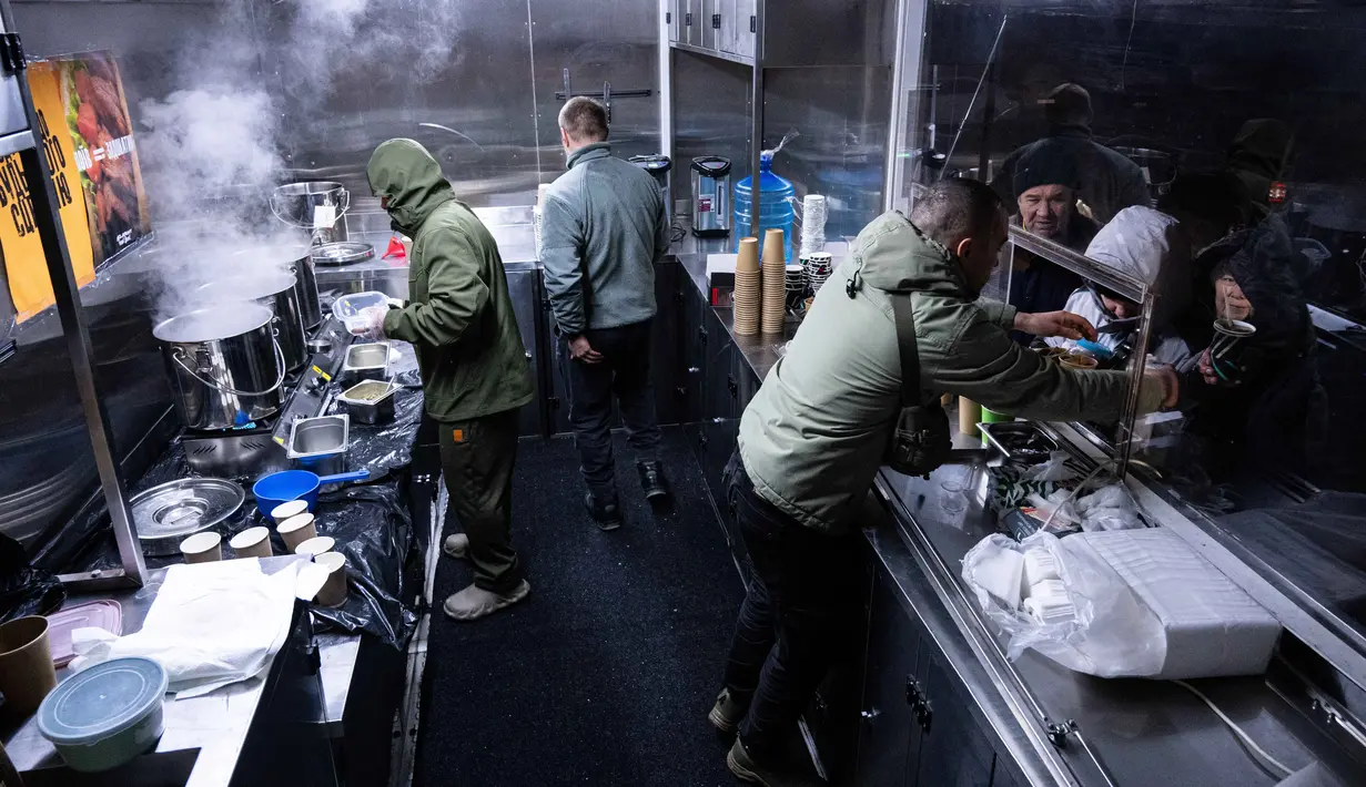 Hampir 80 persen wilayah Ukraina mengalami pemadaman listrik darurat. Tampak dalam foto, para veteran the 3rd Separate Assault Brigade Angkatan Bersenjata Ukraina menyajikan makanan panas gratis bagi orang-orang di lingkungan perumahan yang rumahnya tanpa listrik setelah serangan udara Rusia berulang kali terhadap sektor energi negara itu di Kyiv, Selasa 27 Januari 2026. (AP Photo/Danylo Antoniuk)