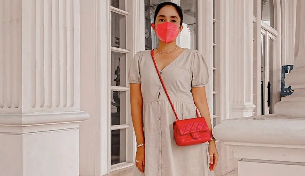 Gaya new normal Ussy mengenakan dress dengan lengan ballon dan detail kancing di bagian depan. Tampilannya semakin chic dengan sling bag dan sepatu berhak merahnya. (Dok. Instagram @ussypratama)