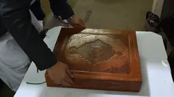 Tampilan Alquran buatan tangan yang dibuat dengan kain sutra di Mourad Khani, Kabul, Afghanistan (19/4). Alquran yang dibuat secara manual ini diharapkan dapat melestarikan tradisi kaligrafi yang telah ada berabad-abad di Afghanistan. (AFP/Wakil Kohsar)