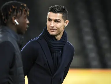 Penyerang Juventus, Cristiano Ronaldo bersama rekannya Moise Kean memeriksa lapangan di Stade de Suisse di Bern (11/12). Juventus akan bertanding melawan Young Boys pada lanjutan grup H Liga Champions. (AFP Photo/Fabrice Coffrini)
