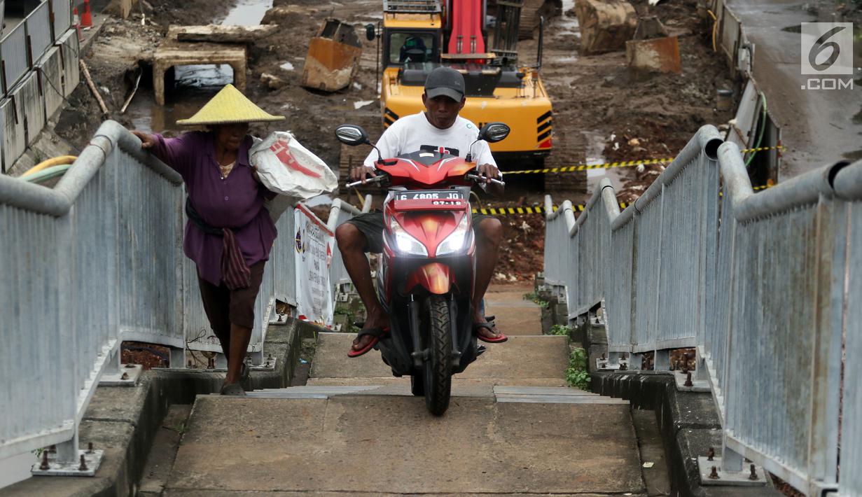 Pengendara motor melintas di samping pejalan kaki menaiki Jembatan Penyeberangan Orang kawasan Cikunir, Bekasi Barat, Senin (12/3). JPO yang diperuntukkan bagi pejalan kaki ini justru digunakan pemotor mencari jalan pintas. (Liputan6.com/Arya Manggala)
