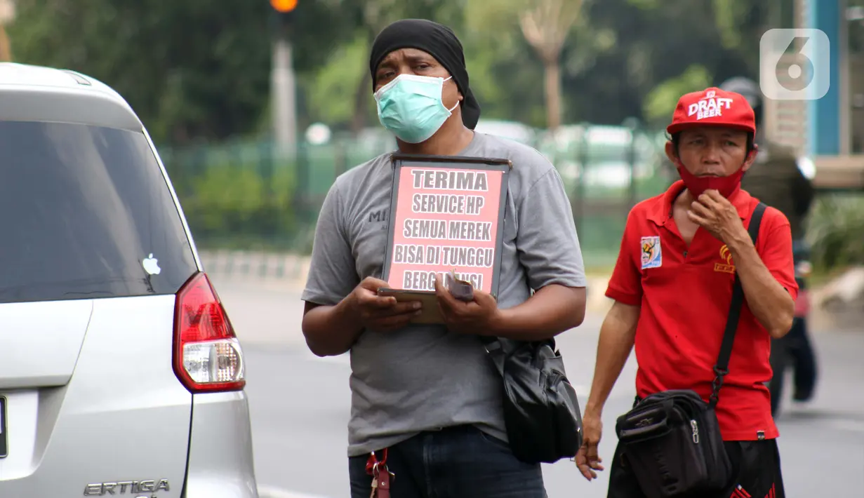 Penjual jasa perbaikan telepon genggam menawarkan jasanya di depan Mall Pusat Grosir Cililitan, Jakarta, Kamis (14/5/2020). Menurut salah satu penjual jasa, aktivitas mereka disebabkan penutupan Mall Pusat Grosir Cililitan sebagai imbas pemberlakuan PSBB.  (Liputan6.com/Helmi Fithriansyah)