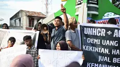 Para pengunjuk rasa memegang poster saat unjuk rasa di Sabang, Provinsi Aceh, Indonesia, Senin (18/12/2023). (AP Photo/Reza Saifullah)