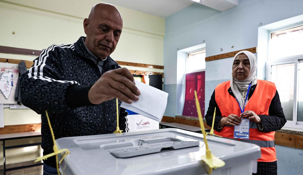 Seorang pria Palestina menggunakan hak politiknya di Tempat Pemungutan Suara (TPS) selama pemilihan kota di Al-Bireh, Tepi Barat yang diduduki Israel, pada Sabtu 25 April 2026. Warga Palestina di Tepi Barat yang diduduki Israel menggunakan hak politik mereka dalam pemilihan kota (pemilu lokal). (Zain JAAFAR/AFP)