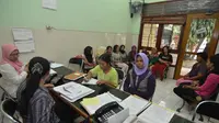 Para pembantu rumah tangga menulis biodatanya kepada lembaga penyalur di Yayasan Bu Gito (24/7/14) (Liputan6.com/JohanTallo)