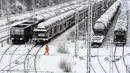 Seorang karyawan berjalan di terminal kereta barang saat salju lebat turun di Munich, Jerman, Rabu (9/1). Salju lebat menyelimuti kota-kota di Jerman. (Christof STACHE/AFP)