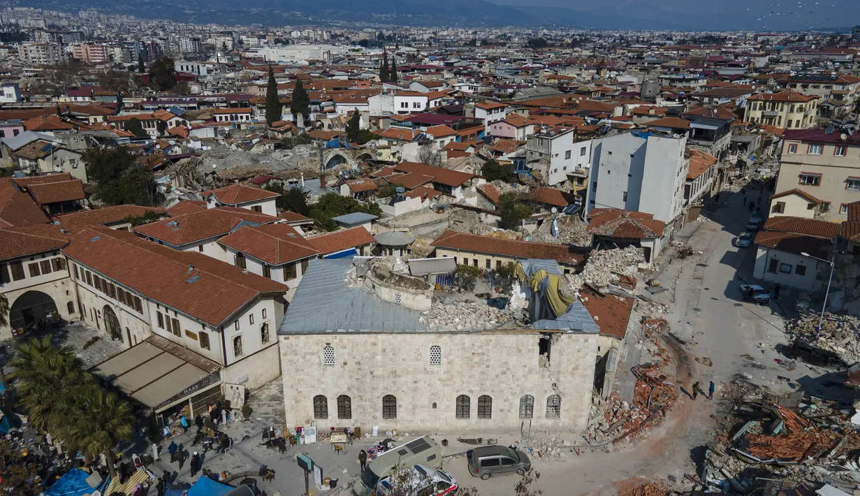 Sebuah foto udara yang diambil pada 11 Februari 2023 menunjukkan masjid Habib-i Neccar yang hancur di kota bersejarah Antakya, Turki. Kubahnya benar-benar runtuh dan situsnya menyerupai gundukan puing. (Photo by Yasin AKGUL / AFP)