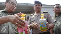 Petugas memperlihatkan produk ilegal di Pelabuhan Tanjung Priok, Jakarta, Senin (6/7/2015). Badan POM RI menyita 8 kontainer produk pertanian dan kosmetik ilegal dengan nilai Rp 13,5 miliar. (Liputan6.com/Faizal Fanani)