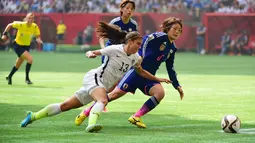 Penyerang AS, Alex Morgan berusaha melewati gelandang Jepang, Mizuho Sakaguchi di final Piala Dunia wanita di BC Place, Vancouver, Kanada, Senin (6/7/2015). Amerika mengalahkan Jepang dengan skor 5-2. (Reuters/Anne Marie Sorvin)