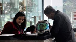 Mengenakan jaket hitam, Anggito Abimanyu tampak membawa masuk helm yang dibawanya ke dalam lobi KPK, Jakarta, (7/9/14). (Liputan6.com/Miftahul Hayat)