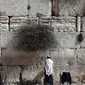 Tembok Ratapan di Yerusalem merupakan dinding batu yang menjulang sekitar 18,9 m dari atas tanah. Tembok ini dianggap situs sakral oleh orang Yahudi, dan ribuan orang berziarah di sana setiap tahun.. (THOMAS COEX / AFP)