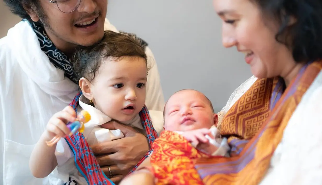 Menemani sang istri, Dimas Anggra kenakan kemeja dan celana pendek putih dengan slayer tenun biru. [@dimsanggara]