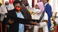 Ibu Negara Iriana Jokowi memberikan kenang-kenangan berupa selendang sutra untuk istri PM Papua Nugini, Rachel Marape. (Foto: Biro Pers Sekretariat Presiden)
