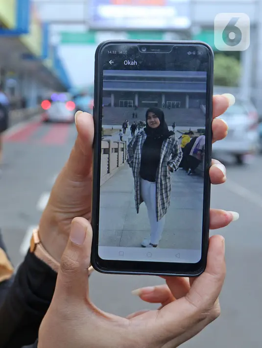Pihak keluarga menunjukan foto anggota saat menunggu kepulangan WNI yang sudah selesai menjalani observasi di Natuna, di Bandara Halim Perdana Kusuma, Jakarta, Sabtu (15/2/2020). Pemerintah resmi memulangkan 238 WNI ke daerah masing-masing karena telah dinyatakan sehat (Liputan6.com/Herman Zakharia)