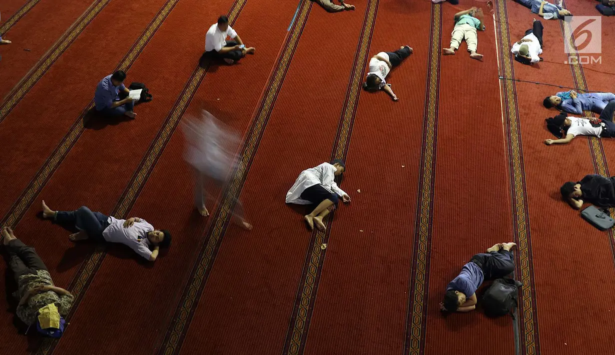 Sejumlah orang beristirahat di dalam Masjid Istiqlal, Jakarta, Kamis (17/5). Pengelola Masjid Istiqlal menyediakan makanan berbuka puasa atau iftar untuk seluruh pengunjung masjid selama bulan Ramadan. (Liputan6.com/Immanuel Antonius)