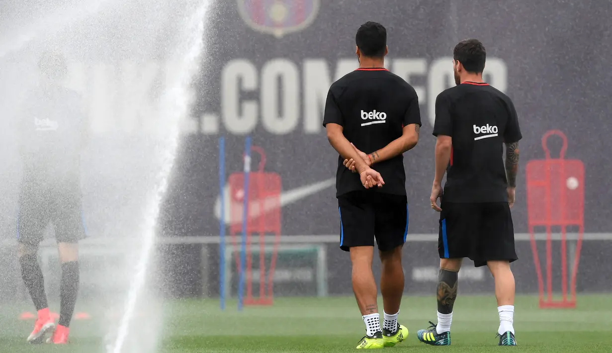 Lionel Messi (kanan) bersama Luis Suarez berbincang saat mengikuti sesi latihan jelang menghadapi Real Madrid di leg kedua Piala Super Spanyol 2017 di Pusat Olahraga FC Barcelona Joan Gamper di Sant Joan Despi, (15/8). (AFP Photo/Lluis Gene)