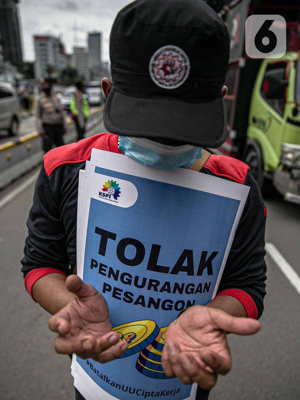 Seorang buruh yang tergabung dalam Serikat Pekerja Indonesia (KSPI) berdoa saat mengikuti unjuk rasa menyuarakan penolakan kaum buruh terhadap omnibus law UU Cipta Kerja di kawasan Patung Kuda, Jakarta, Rabu (16/12/2020). Unjuk rasa ini dihadiri ratusan buruh. (Liputan6.com/Faizal Fanani)