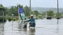 Seorang pria mendorong sepedanya melewati jalanan yang tergenang air di kota Hpa Yar Gyi di wilayah Bago, Myanmar, pada tanggal 9 Oktober 2023. (SAI AUNG MAIN/AFP)