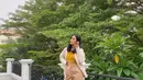 Tampilan kekinian Alika Islamadina dengan kemeja putih sebagai outer dan bandeau top kuning mustard sebagai inner. Untuk bawahan, kamu bisa pilih high waist pants warna nude. (Instagram/alikaislamadina).