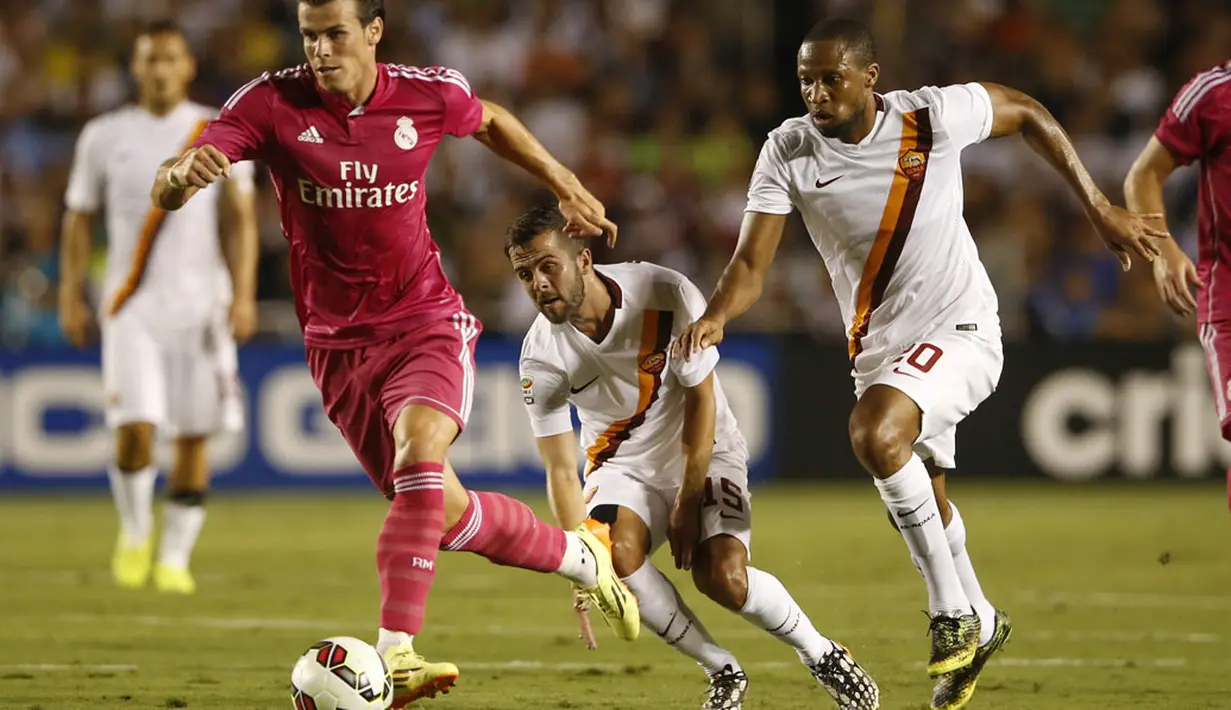 Gelandang Real Madrid, Gareth Bale (kiri), berhasil melewati hadangan dua pemain AS Roma saat berlaga di International Champions Cup 2014 di Stadion Cotton Bowl, Dallas, (29/7/2014). (REUTERS/Kevin Jairaj-USA TODAY Sports)