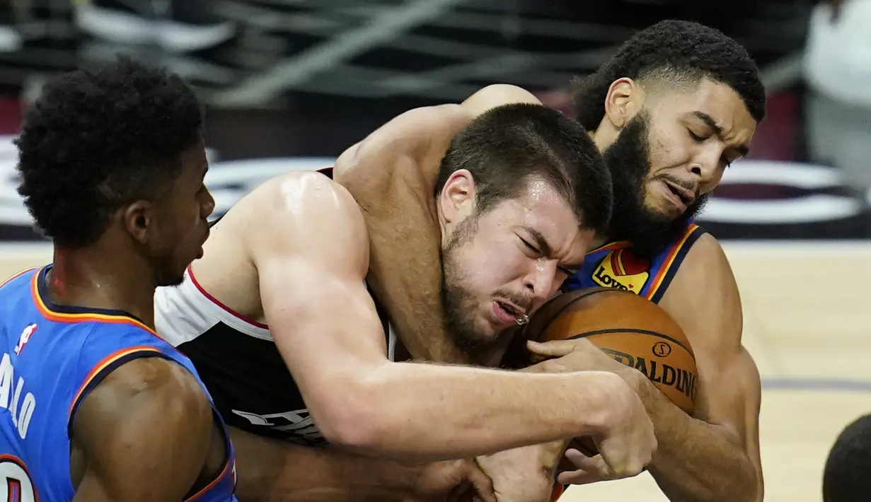 Pebasket Los Angeles Clippers, Ivica Zubac (tengah) berebut bola dengan pebasket Oklahoma City Thunder, Kenrich Williams (kanan). (Foto: AP/Ashley Landis)
