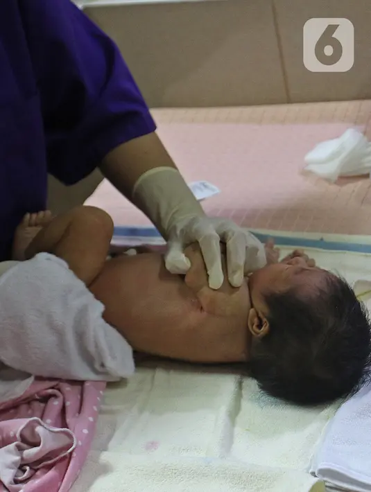 Perawat saat mempraktekan cara memandikan bayi kepada seorang ibu di RSIA Tambak, Jakarta, Kamis (18/02/2021). Melatih para ibu baru untuk memandikan bayi pertama tersebut dilakukan dengan menerapkan protokol kesehatan ketat. (Liputan6.com/Herman Zakharia)