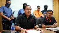 Agus berpakaian orange tersangka pembunuh Tardi saat diamankan di kantor Direktorat Reserse Kriminal Umum Polda Riau. (Liputan6.com/ M Syukur)