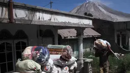 Warga desa Gamber mengemasi barang-barangnya untuk mencegah letusan susulan Gunung Sinabung, Karo, Sumatera Utara, (23/5). Bencana tersebut menyebabkan 7 orang meninggal dan 2 orang mengalami luka bakar akibat terkena awan panas. (Albert Damanik / AFP)