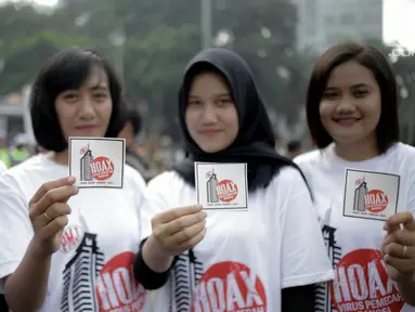 Peserta memperlihatkan stiker pesan antihoax pada  kampanye sekaligus deklarasi saat car free day di Bundaran Hotel Indonesia, Jakarta, Minggu (18/3). Kegiatan digelar Polda Metro Jaya bersama Indonesia Comunitas Club. (Liputan6.com/Faizal Fanani)