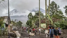 Orang-orang berjalan di tanah yang tertutup abu vulkanik setelah aliran piroklastik selama letusan Gunung Semeru di Desa Supiturang, Lumajang, Jawa Timur pada Kamis 20 November 2025. Gunung Semeru kembali mengalami erupsi pada Rabu (19/11/2025) sore. (Agus Harianto/AFP)