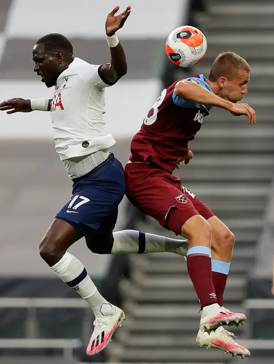 Gelandang Tottenham Hotspur, Moussa Sissoko (kiri) berebut bola udara dengan gelandang West Ham United, Tomas Soucek pada pertandingan lanjutan Liga Inggris di Stadion Tottenham Hotspur di London (23/6/2020). Tottenham menang 2-0 atas West Ham. (AFP/Pool/Kirsty Wigglesworth)