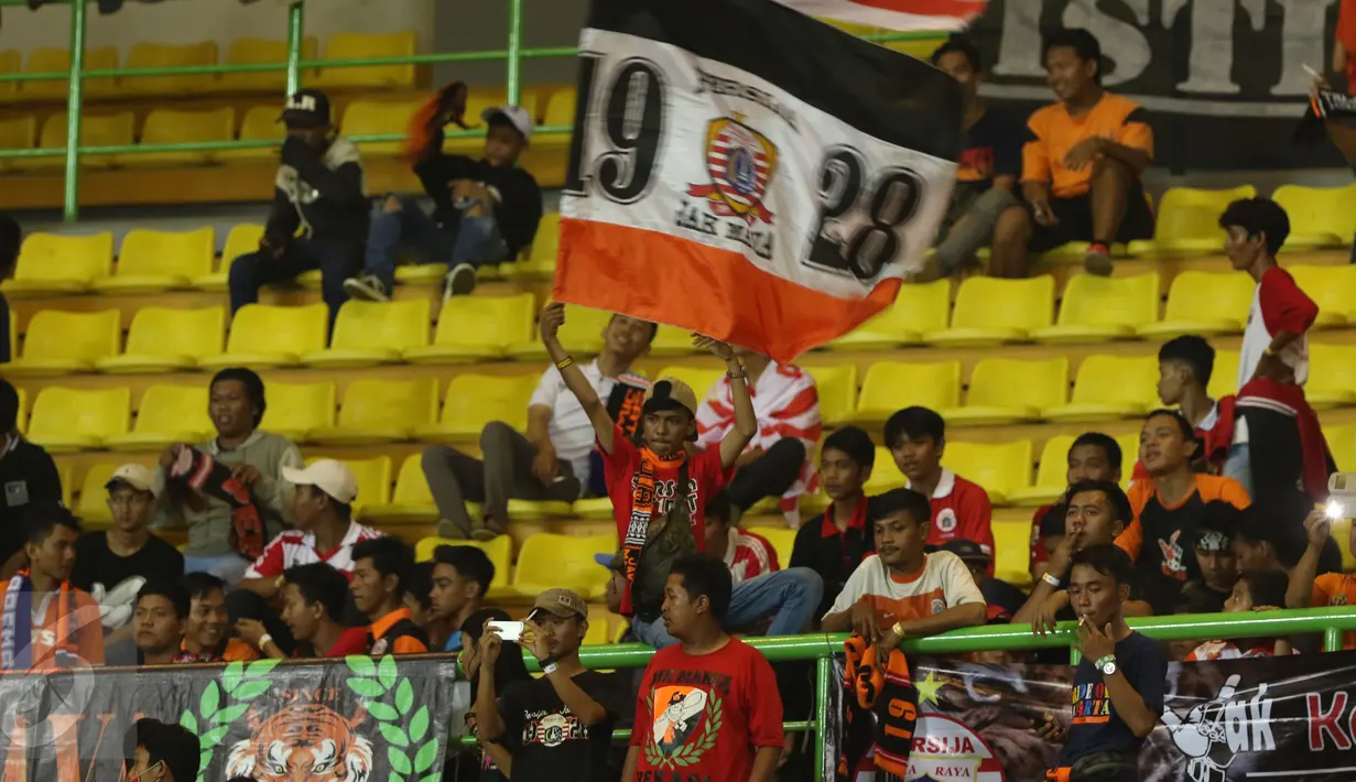 Suporter mengibarkan bendera jelang menyaksikan laga Persija melawan Timnas Indonesia U-22 di Stadion Patriot Candrabhaga, Bekasi, Rabu (5/4). Laga Persija melawan Timnas Indonesia U-22 berakhir imbang 0-0. (Liputan6.com/Helmi Fithriansyah)