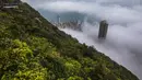 Orang-orang berkumpul di sudut pandang Peak untuk menyaksikan kabut di atas Hong Kong, Selasa (22/3/2022). Kabut tebal menyelimuti Hong Kong pada musim semi ketika wilayah tersebut dipengaruhi oleh udara dingin dan hangat bergantian. (AFP/Dale De La Rey)