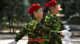 Sejumlah wanita lansia melakukan baris berbaris mengenakan pakaian bergaya militer saat mengikuti Hari Kebugaran Nasional di Beijing, Tiongkok (8/8). Para lansia ini tampil lincah dalam peringantan Hari Kebugaran Nasional tersebut. (AFP Photo/Greg Baker)