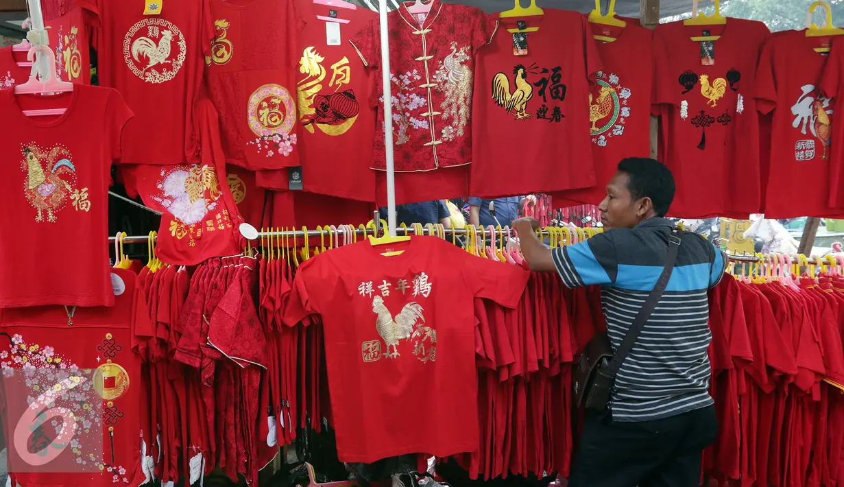Seorang penjual pakaian yang bertemakan Imlek menunggu pembeli di Glodok, Jakarta, Rabu (18/01). Menjelang imlek, pedagang mulai marak menjual pernak-pernik Imlek yang berwarna serba merah. (Liputan6.com/JohanTallo)