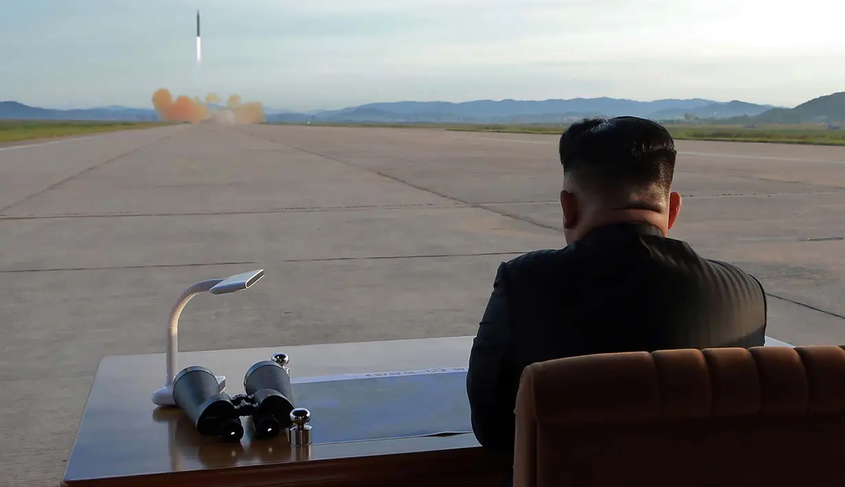 Pemimpin Korea Utara, Kim Jong-Un menyaksikan uji coba peluncuran rudal balistik Hwasong-12 di lokasi yang tidak diketahui pada foto yang dirilis Sabtu (16/9). Kim mengaku ingin "menyamai kekuatan militer Amerika Serikat. (STR / KCNA VIA KNS / AFP)