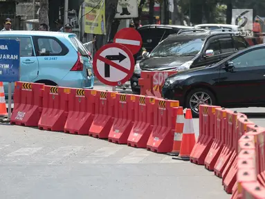 Petugas mengatur lalu lintas saat uji coba sistem satu arah di Jalan KH Wahid Hasyim, Jakarta, Selasa (9/10). Dalam uji coba tersebut, kendaraan dari arah Jalan Agus Salim dilarang berbelok menuju Jalan KH Wahid Hasyim. (Liputan6.com/Faizal Fanani)
