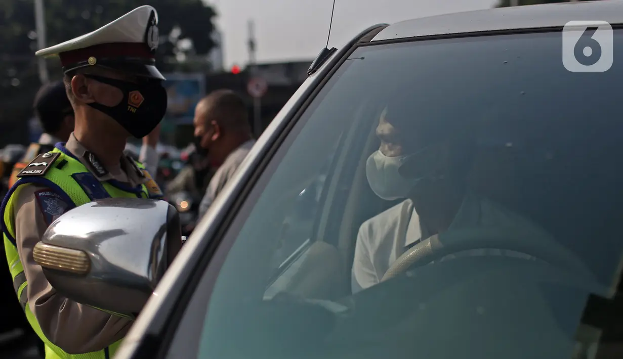 Polisi menghentikan mobil saat pemberlakuan ganjil genap di kawasan Fatmawati, Jakarta, Senin (25/10/2021). Pemberlakuan ganjil genap di DKI Jakarta diperluas menjadi 13 titik. (Liputan6.com/Herman Zakharia)