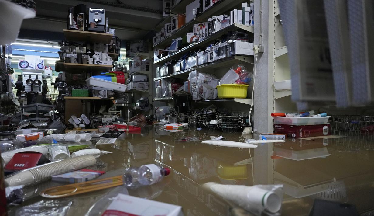 Barang-barang mengapung di atas air di dalam sebuah toko yang dilanda banjir saat hujan deras semalaman di Alges, tepat di luar Lisbon, Selasa (13/12/2022). Badai Atlantik menghantam semenanjung Iberia, meninggalkan jejak kehancuran pada Selasa, terutama di Ibu kota Portugal,  Lisbon, sebelum pindah ke timur ke Spanyol.  (AP Photo/Armando Franca)