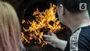 Warga keturunan Tionghoa membakar kertas saat sembahyang Tahun Baru Imlek 2573 Kongzili di Vihara Amurva Bhumi, Jakarta, Selasa (1/2/2022). Pengurus membatasi 50 persen pengunjung dari kapasitas normal dalam kegiatan sembahyang Imlek guna mencegah penularan Covid-19. (merdeka.com/Iqbal S Nugroho)