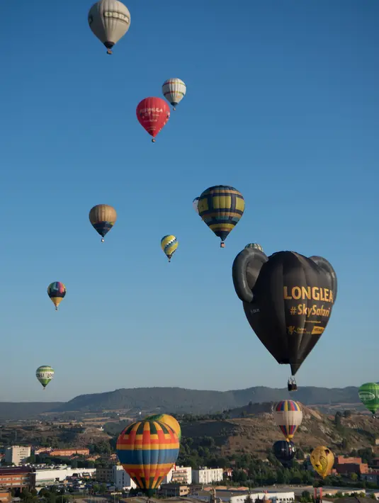 Puluhan balon udara terbang selama Festival Balon Eropa ke-23 di Igualada, Barcelona (11/7/2019). Festival Balon Eropa adalah yang terbesar di negara tersebut dan salah satu yang terbesar di Eropa. (AFP Photo/Josep Lago)