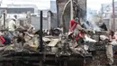 Warga memunguti sisa barang di pemukiman yang hangus terbakar di kawasan Duri Utara, Tambora, Jakarta, Rabu (12/8/2020). Kebakaran besar terjadi di kawasan padat penduduk di Jalan Duri Utara, Tambora, Selasa (11/8) malam, diduga akibat korsleting listrik. (Liputan6.com/Helmi Fithriansyah)