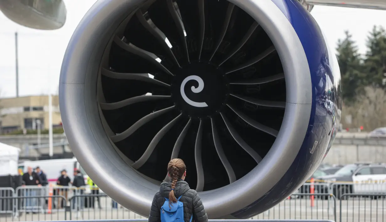 Seorang wanita berdiri di depan mesin pesawat Boeing 747 terakhir selama upacara untuk menandai pengirimannya, di Boeing Future of Flight Museum di Everett, Washington, pada 31 Januari 2023. Dikenal sebagai "Queen of the Skies", 747 adalah pesawat jet lorong ganda pertama di dunia, yang dirancang dan dibangun oleh Boeing dalam 28 bulan dan diperkenalkan oleh Pan Am pada tahun 1970. (Jason Redmond / AFP)