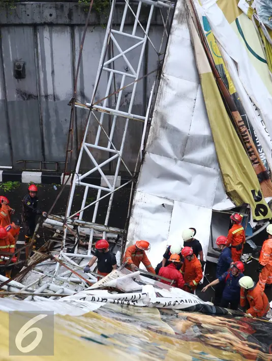 Petugas berusaha memotong bagian JPO yang roboh di Jalan Raya Pasar Minggu, Jakarta Selatan, Sabtu (24/09). Korban meninggal akibat JPO roboh dibawa ke RS Siaga Pasar Minggu. (Liputan6.com/Immanuel Antonius)
