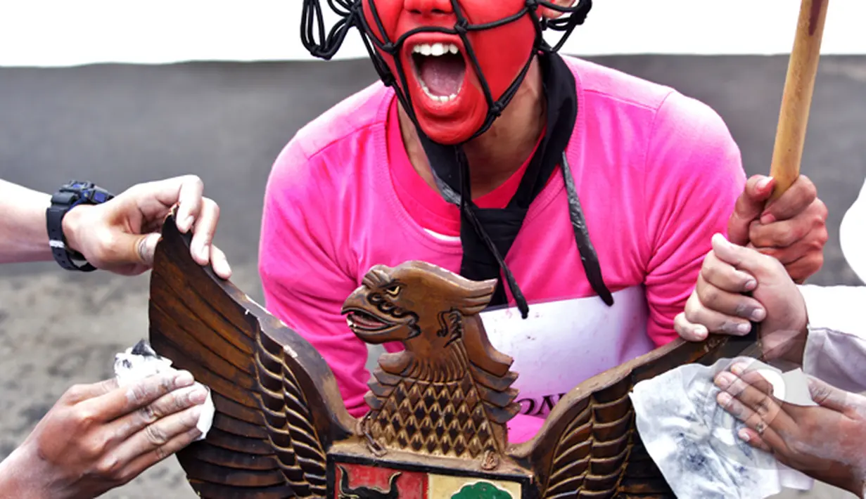 Ratusan simpatisan Koalisi Masyarakat Pengawal Konstitusi (Kompak) melakukan aksi ke Istana Negara, Jakarta, Rabu (11/2/2015). Tampak patung lambang Garuda ikut dibawa dalam aksi teaterikal. (Liputan6.com/Faizal Fanani)