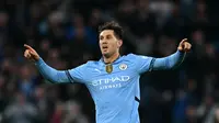 Bek Manchester City, John Stones, mencetak gol ke gawang Arsenal dalam laga pekan kelima Premier League 2024/2025 di Etihad Stadium, Minggu (22/9/2024) malam WIB. Gol ini menyelamatkan The Citizens dari kekalahan di depan pendukungnya. (Paul ELLIS / AFP)