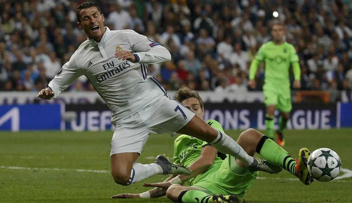 Bintang Real Madrid, Cristiano Ronaldo, dijatuhkan pemain Sporting Lisbon, Sebastian Coates. Pada laga ini wasit memberikan tiga kartu kuning untuk Sporting dan satu untuk pemain El Real. (Reuters/Juan Medina)