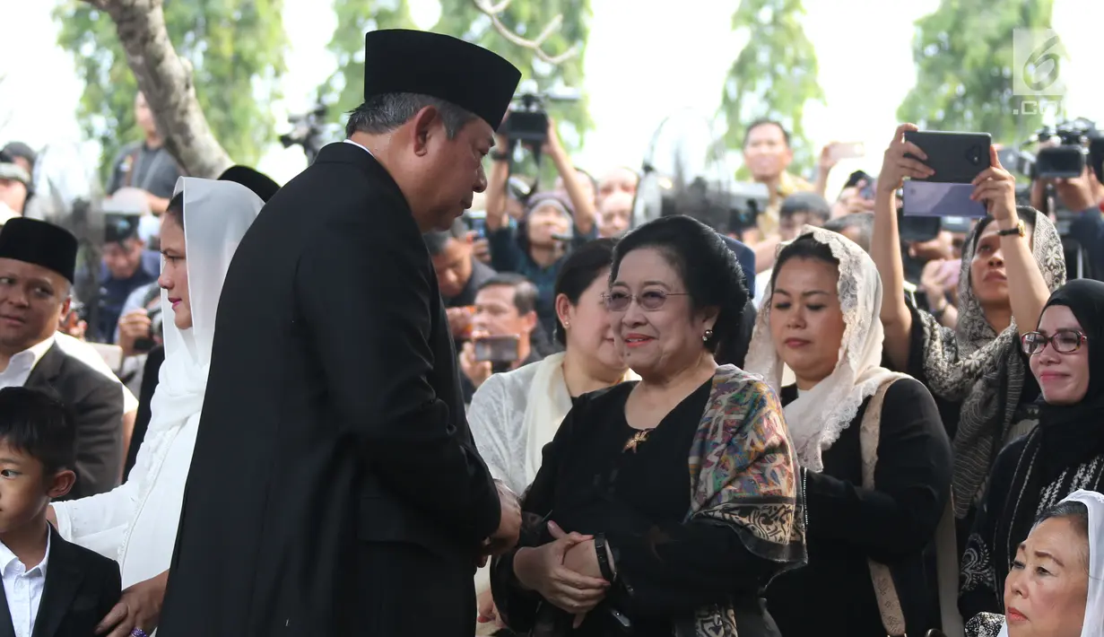Presiden ke-6 RI Susilo Bambang Yudhoyono bersalaman dengan Presiden ke-5 RI Megawati Soekarnoputri usai prosesi pemakaman Ani Yudhoyono di TMP Kalibata, Jakarta, Minggu (2/6/2019). Megawati tampak melempar senyum kepada SBY disamping Sinta Nuriyah Wahid. (Liputan6.com/HO/Rangga)