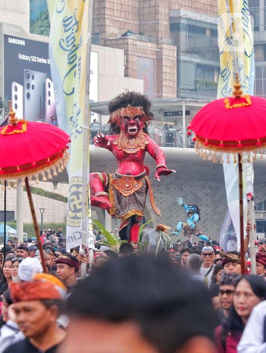 Umat Hindu mengarak ogoh-ogoh saat hari bebas berkendara di kawasan Bundaran HI, Jakarta, Minggu (12/3/2023). Pawai ogoh-ogoh tersebut diselenggarakan dalam rangka menyambut Perayaan Nyepi Tahun Baru Saka 1945/2023. (Liputan6.com/Angga Yuniar)