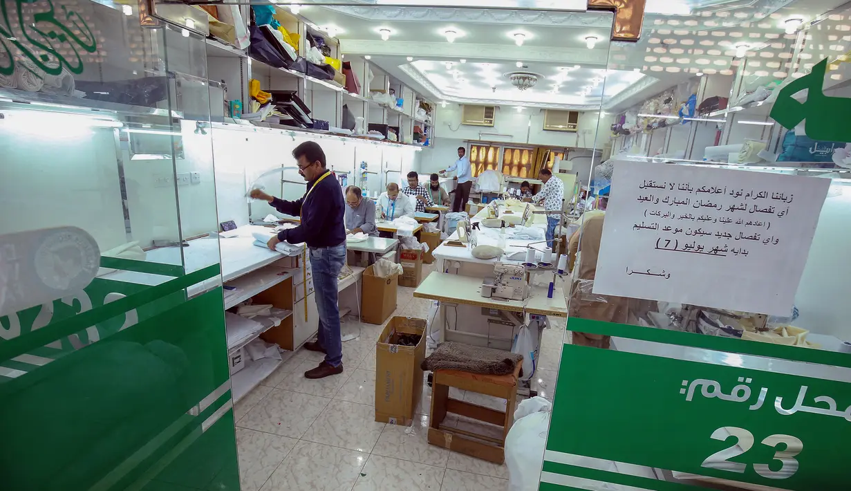 <p>Penjahit menyelesaikan produksi di tengah tingginya permintaan "dishdasha", pakaian tradisional Kuwait, di toko pakaian adat di Kuwait City pada 23 April 2022. Selama bulan suci Ramadhan dan Idul Fitri, pria dan anak laki-laki lebih suka memakai pakaian tradisional Kuwait. (YASSER AL-ZAYYAT / AFP)</p>